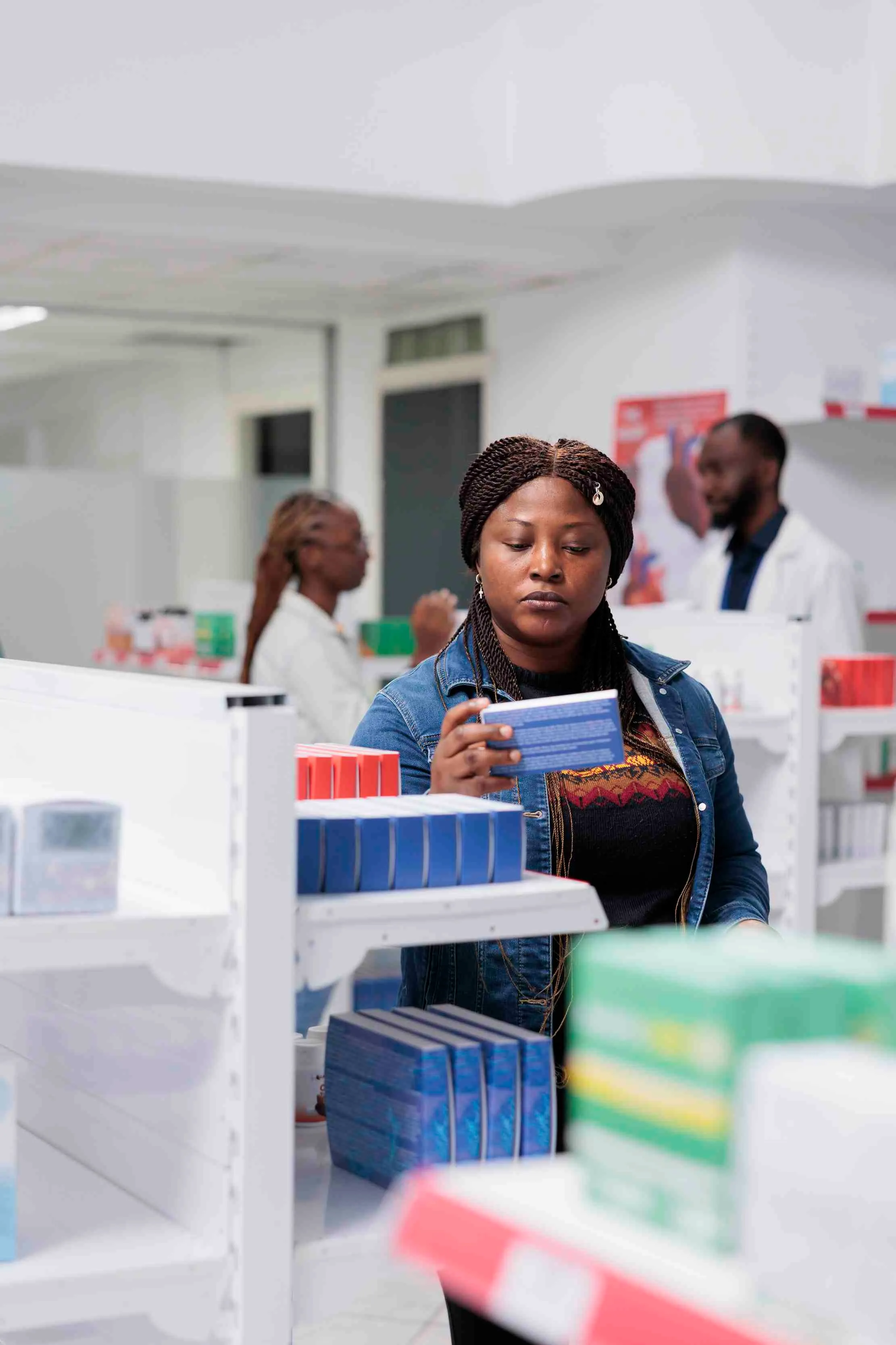 Pharmacy customer reading medicine instructions while standing near the drugstore shelf