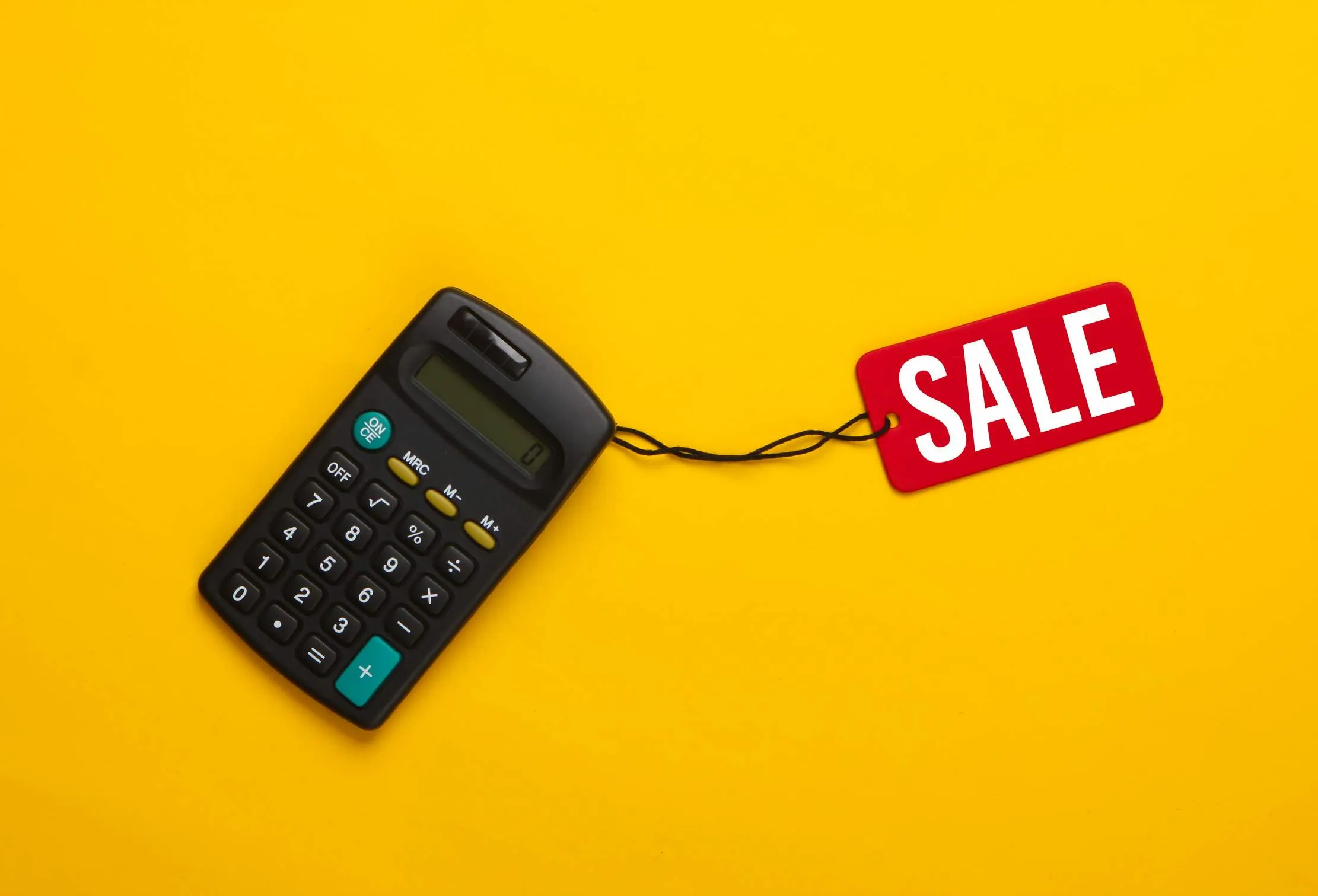 Calculator and sale tag representing promotions, discounts, and margin checks