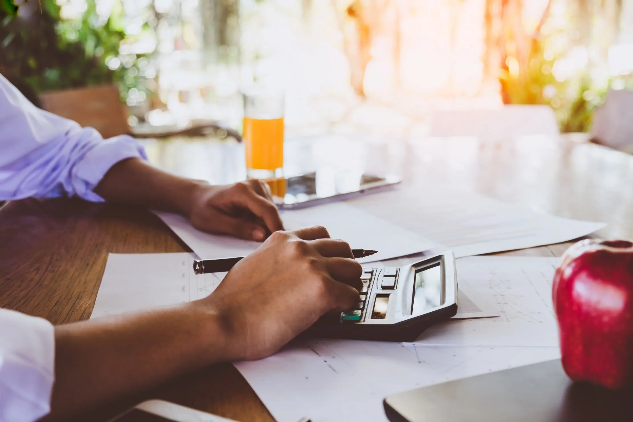 Business owner reviewing figures with a calculator before making a customer credit decision