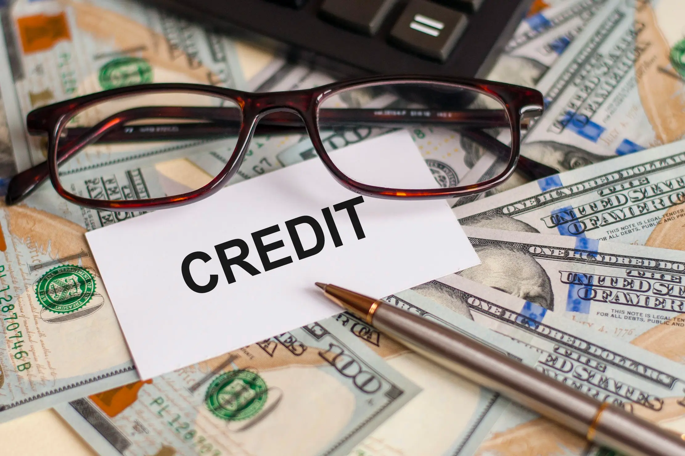 Credit account paperwork and calculator representing an outstanding customer balance record