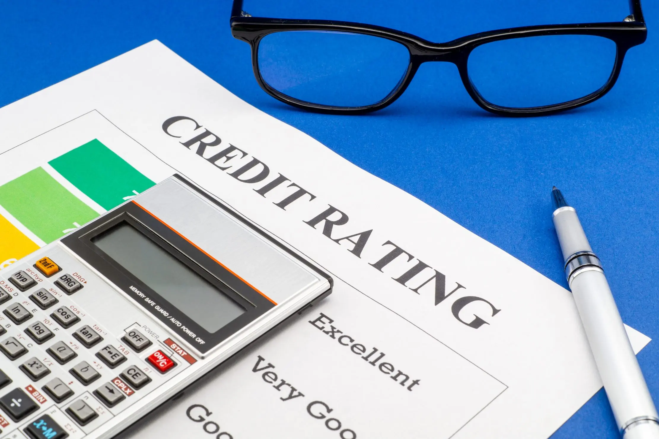 Credit review worksheet, calculator and glasses representing a documented customer limit decision
