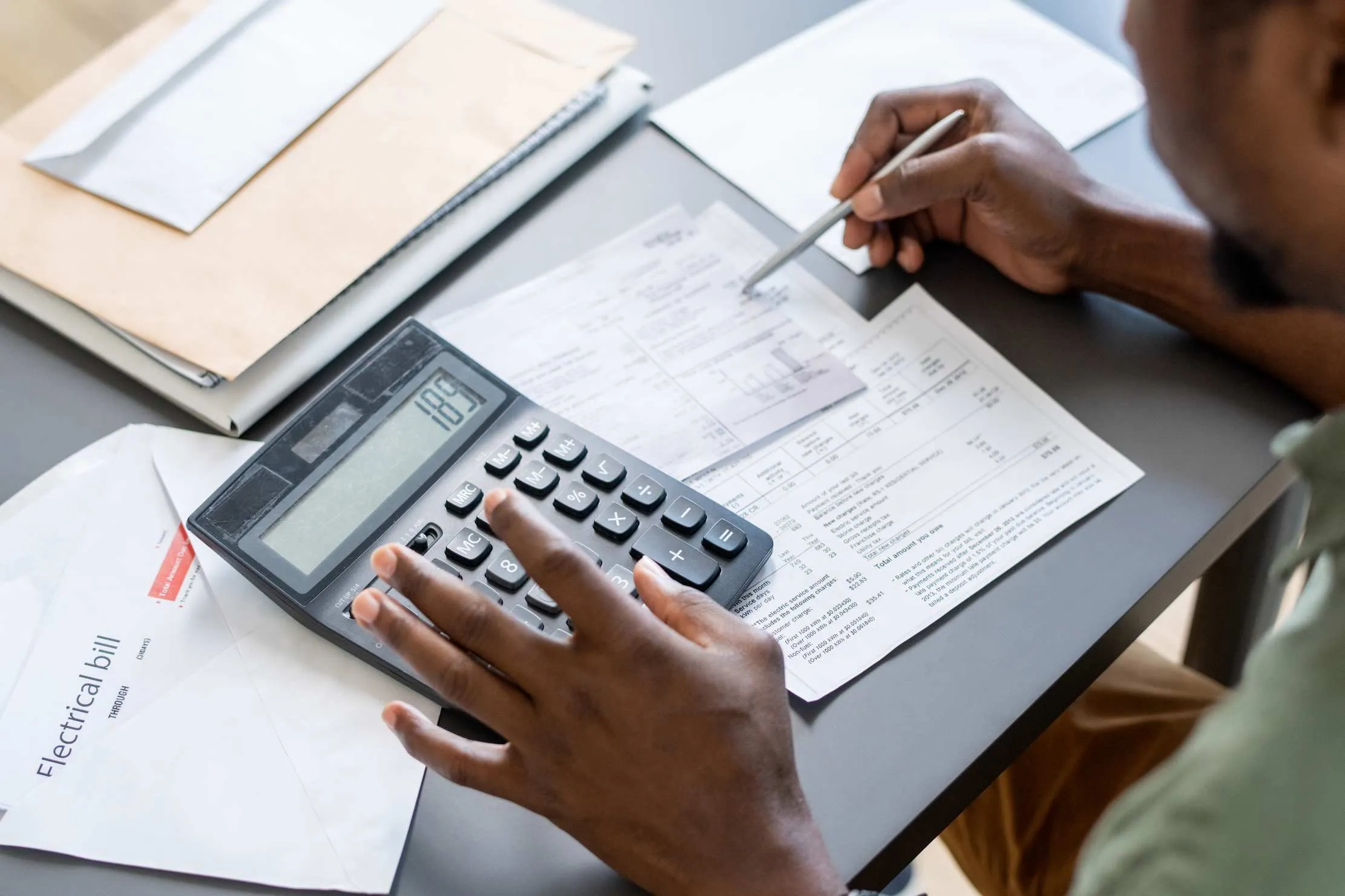 Hands using a calculator for petty cash, expenses, and account reconciliation