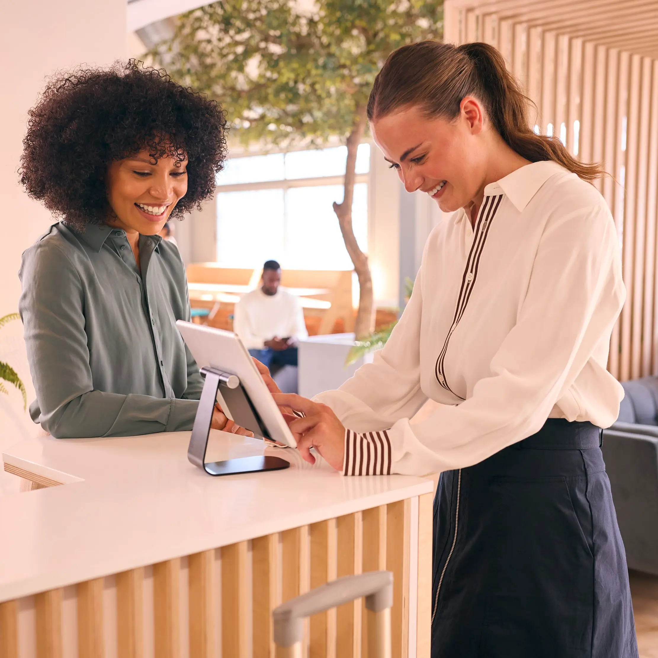 Hotel staff using a tablet at reception, illustrating Maduuka hotel and resort operations