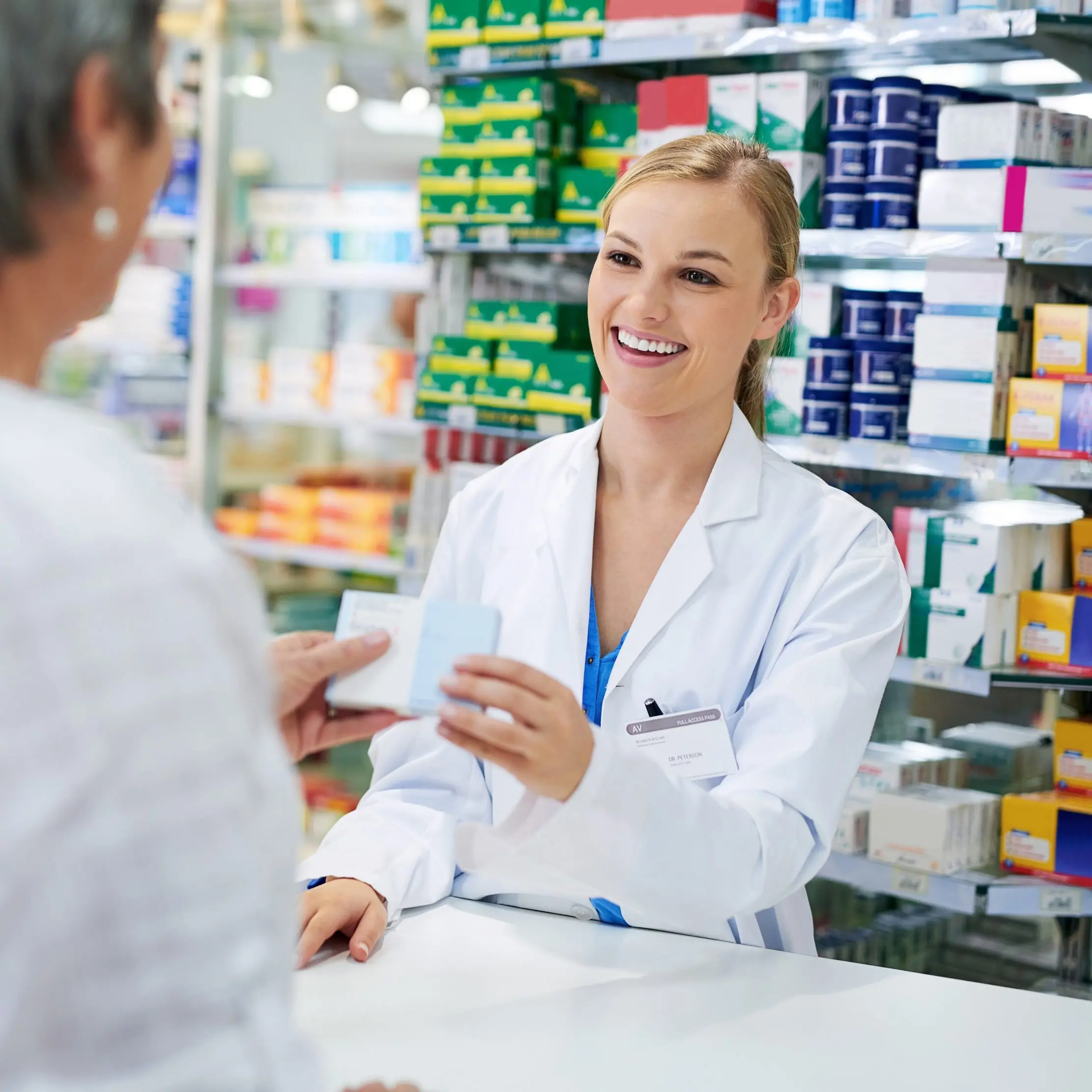 Pharmacist advising a customer at a medicine counter, illustrating Maduuka pharmacy workflows