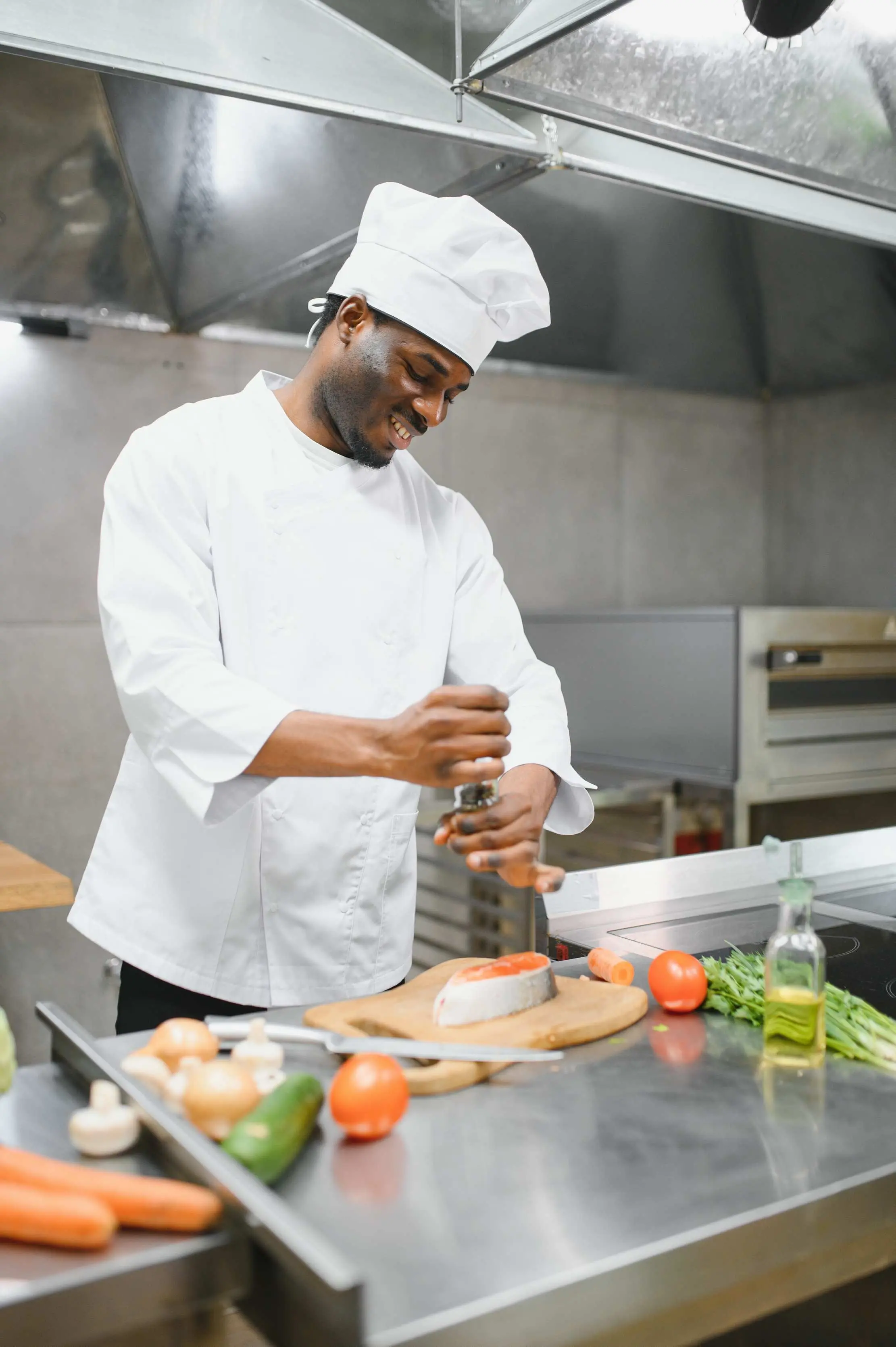 Chef seasoning a portion beside prepared ingredients in a restaurant kitchen