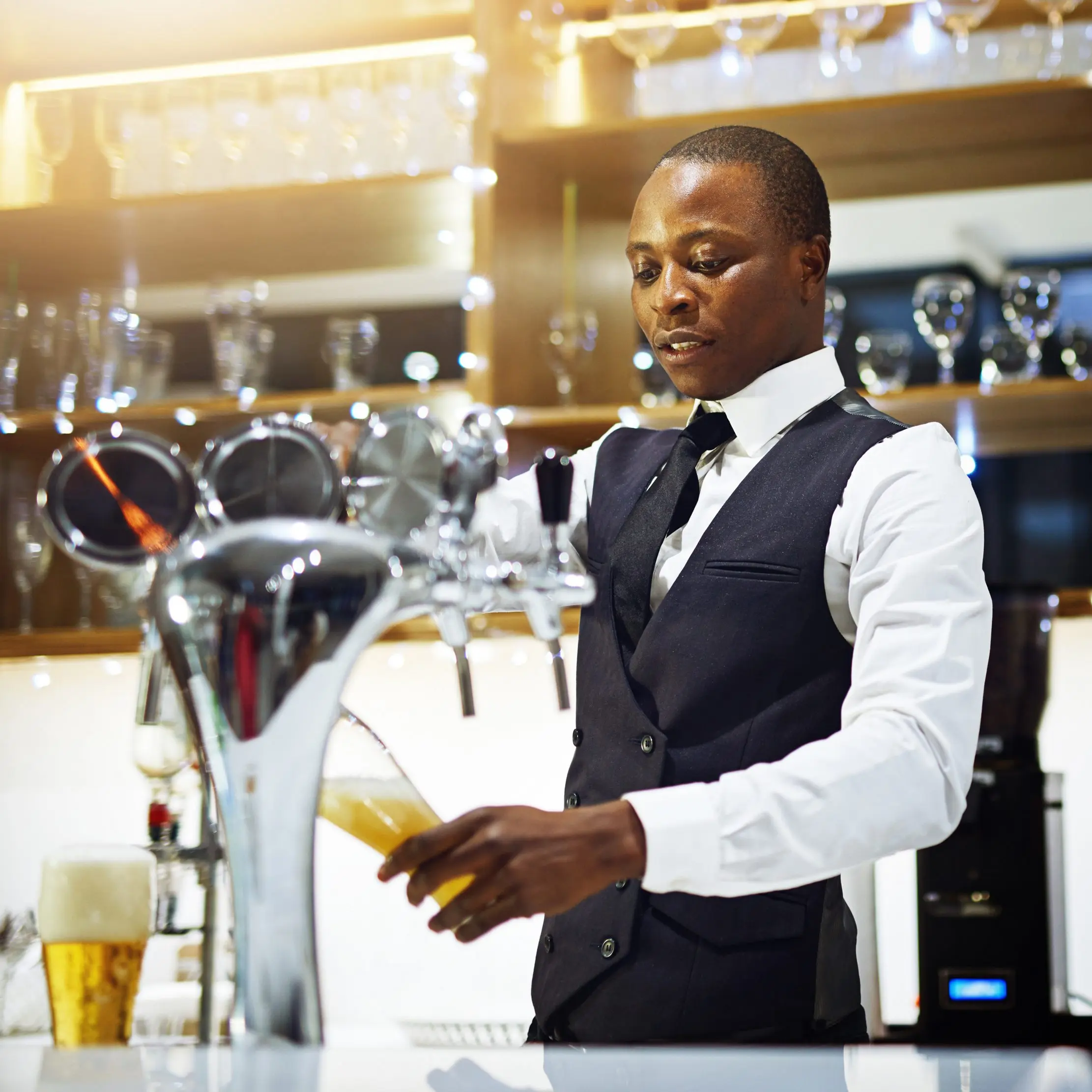 Bartender serving a drink at a hospitality counter, illustrating Maduuka restaurant and bar operations