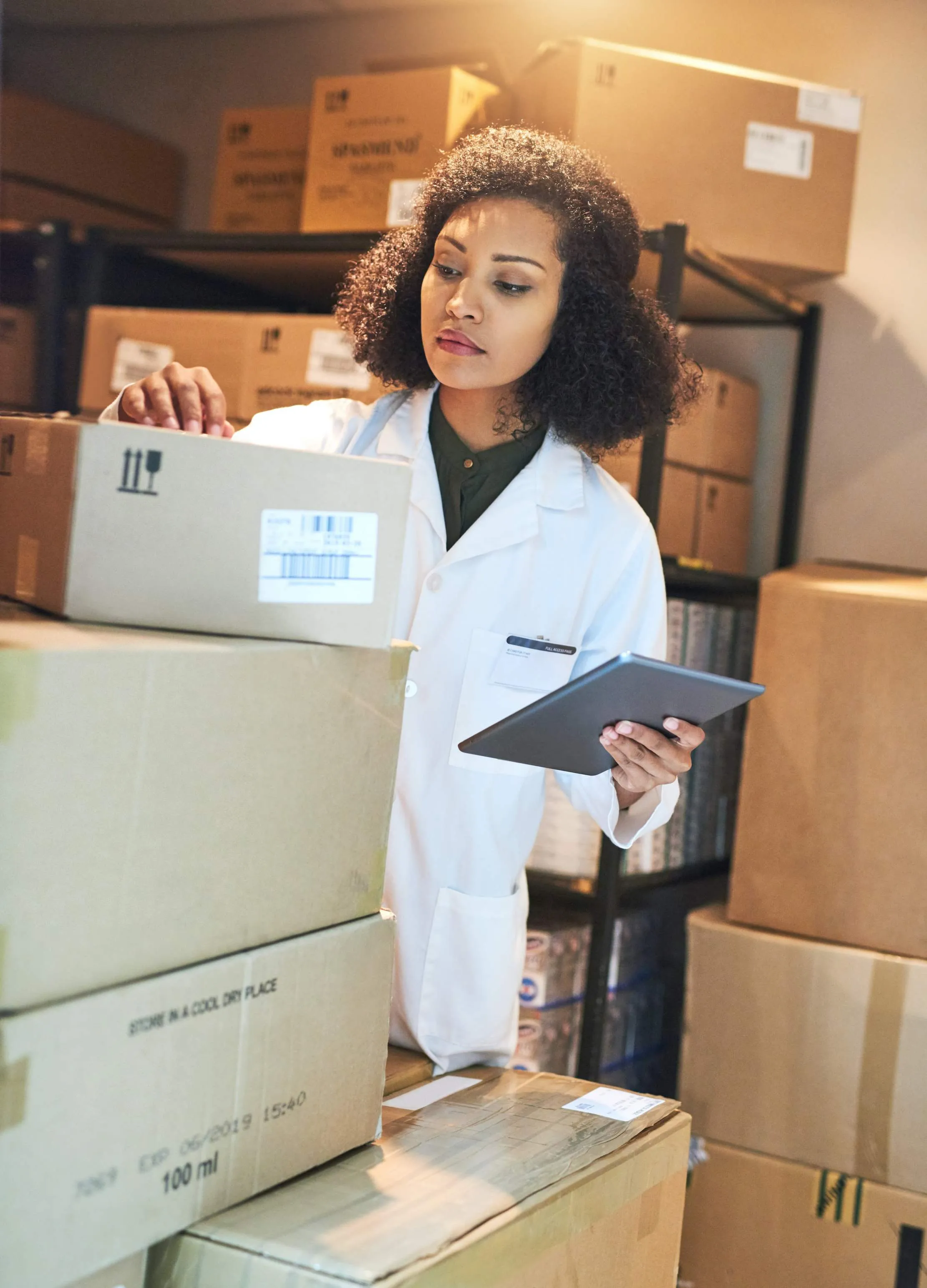 Pharmacy employee using a tablet to check medicine stock, expiry dates, and supply records